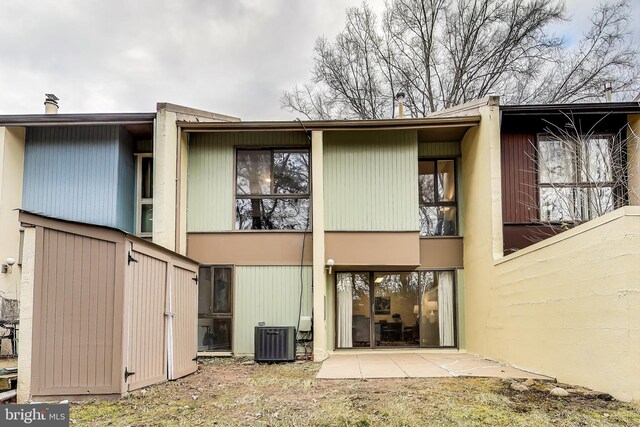 back of property with central AC and a patio area