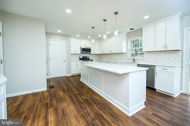 kitchen with white cabinets, a kitchen island, sink, and stainless steel appliances