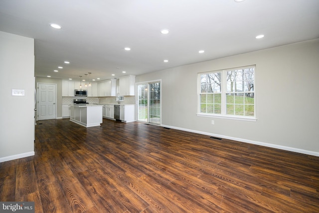 unfurnished living room featuring dark wood-type flooring