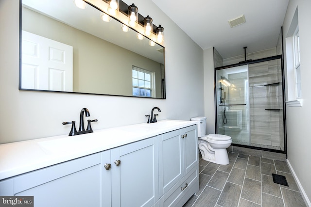 bathroom with vanity, toilet, and walk in shower