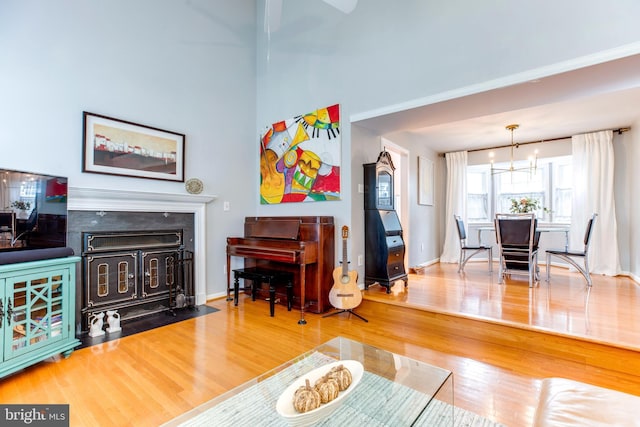 living room featuring an inviting chandelier, a fireplace, and wood-type flooring