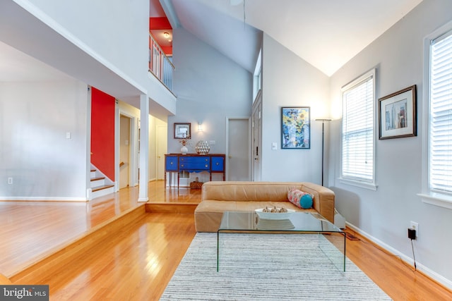 living room featuring high vaulted ceiling and wood-type flooring