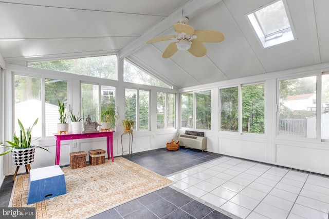 sunroom featuring a wall mounted air conditioner, ceiling fan, vaulted ceiling with skylight, and plenty of natural light