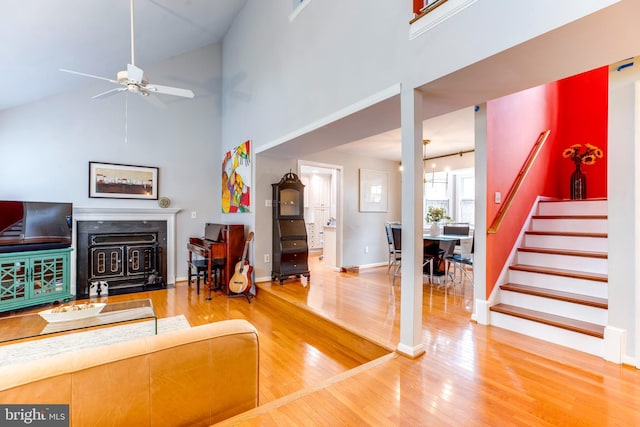 living room with ceiling fan, high vaulted ceiling, and hardwood / wood-style flooring