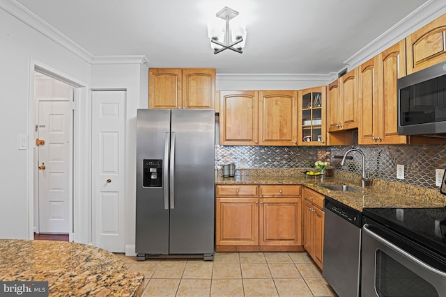 kitchen featuring crown molding, sink, dark stone countertops, light tile patterned floors, and stainless steel appliances