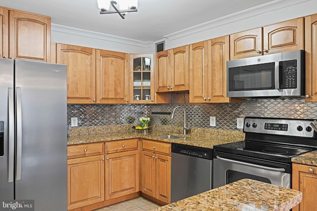 kitchen with light stone countertops, appliances with stainless steel finishes, decorative backsplash, ornamental molding, and sink