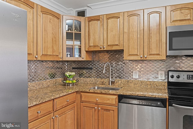 kitchen with light stone counters, sink, appliances with stainless steel finishes, and tasteful backsplash