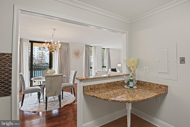 dining space featuring a chandelier, electric panel, plenty of natural light, and crown molding