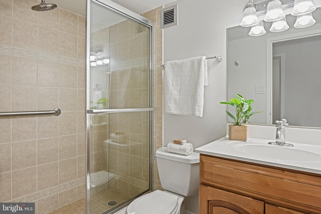 bathroom with toilet, vanity, and walk in shower