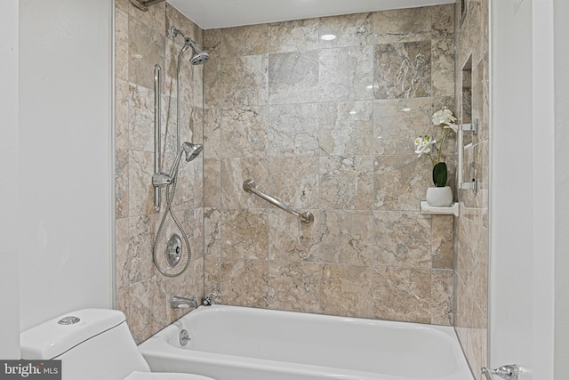 bathroom featuring tiled shower / bath combo and toilet