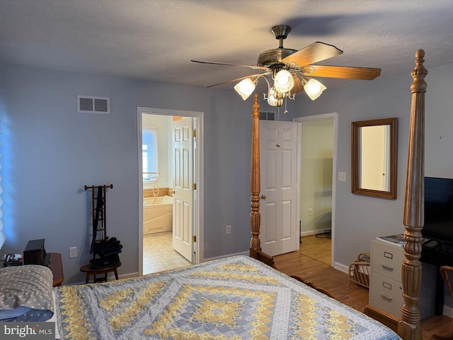 bedroom with ensuite bathroom, ceiling fan, light hardwood / wood-style floors, and a textured ceiling