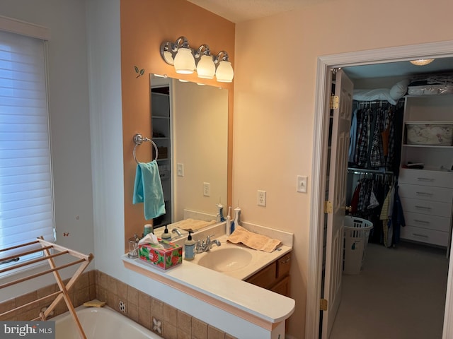 bathroom featuring a washtub and vanity