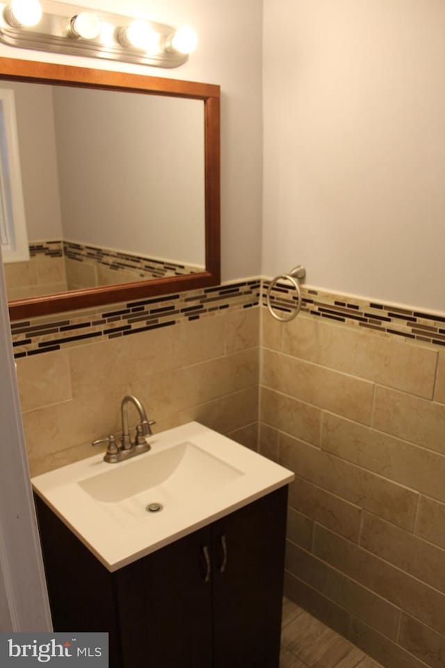 bathroom featuring vanity and tile walls