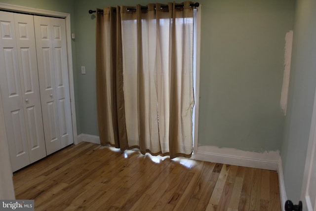 unfurnished bedroom with a closet and light hardwood / wood-style floors