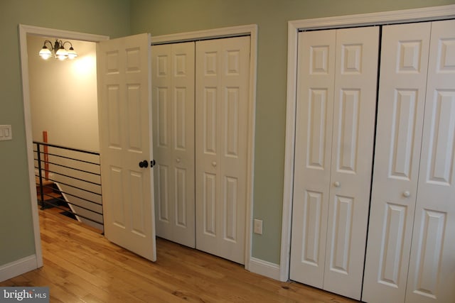 bedroom featuring light hardwood / wood-style floors and multiple closets