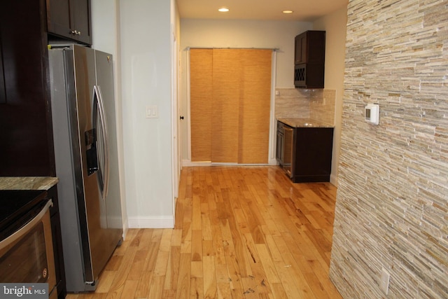 kitchen featuring backsplash, dark brown cabinetry, stainless steel fridge with ice dispenser, and light wood-type flooring