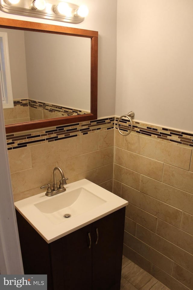 bathroom featuring vanity and tile walls