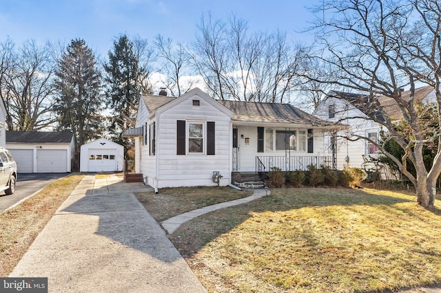 view of front of home with a porch, a garage, an outbuilding, and a front yard