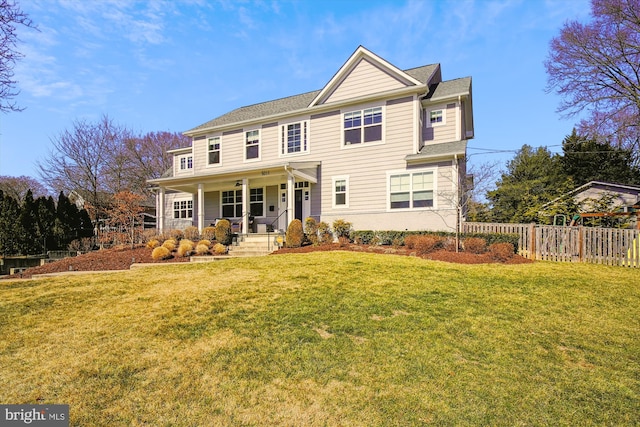 view of front of property with covered porch, a front lawn, and fence