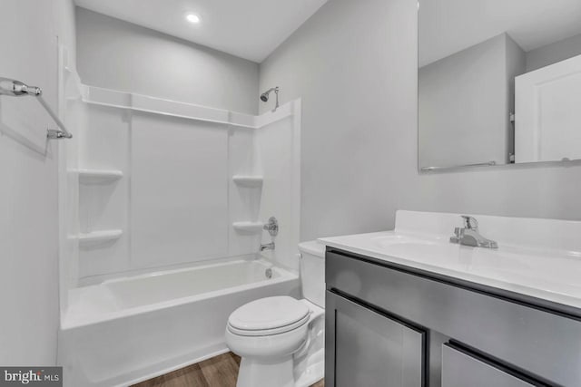 full bathroom with hardwood / wood-style floors, vanity, toilet, and shower / washtub combination