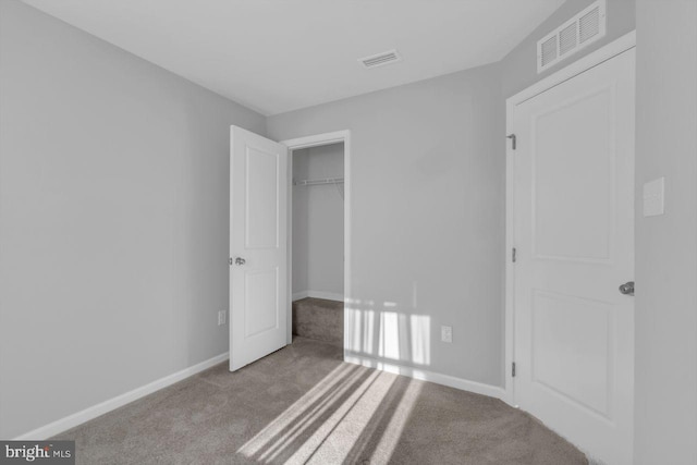 unfurnished bedroom with a closet and light colored carpet