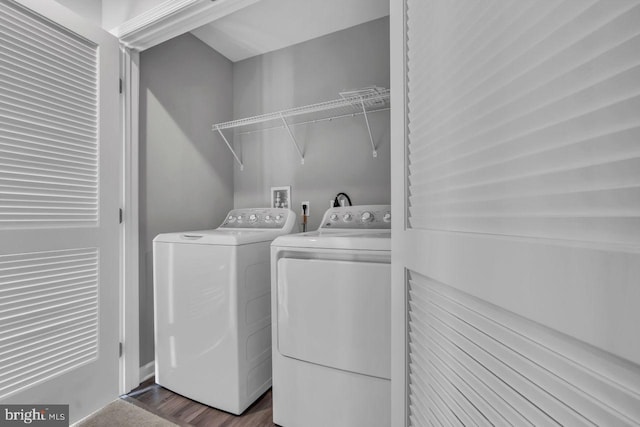 clothes washing area featuring washer and clothes dryer and dark wood-type flooring