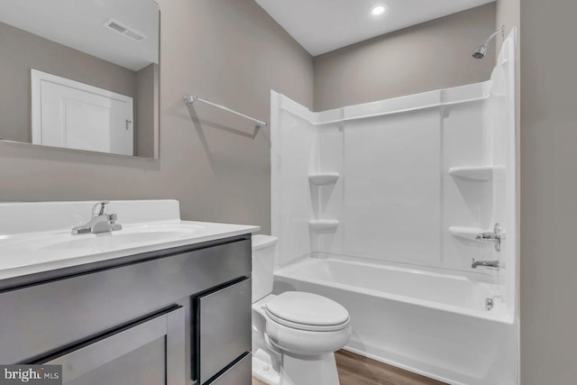 full bathroom featuring bathing tub / shower combination, hardwood / wood-style floors, vanity, and toilet