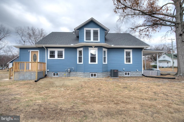 rear view of house featuring central AC unit and a lawn