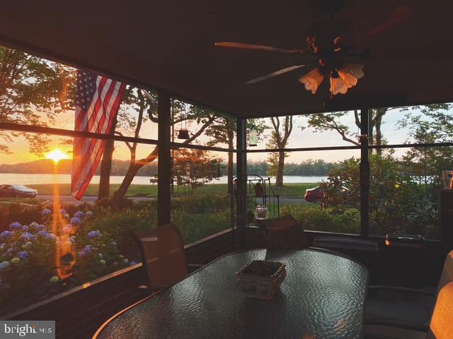 exterior space featuring ceiling fan and a water view