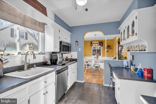 kitchen with backsplash, white cabinetry, sink, and appliances with stainless steel finishes