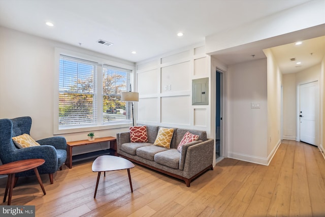 living room with electric panel and light hardwood / wood-style floors