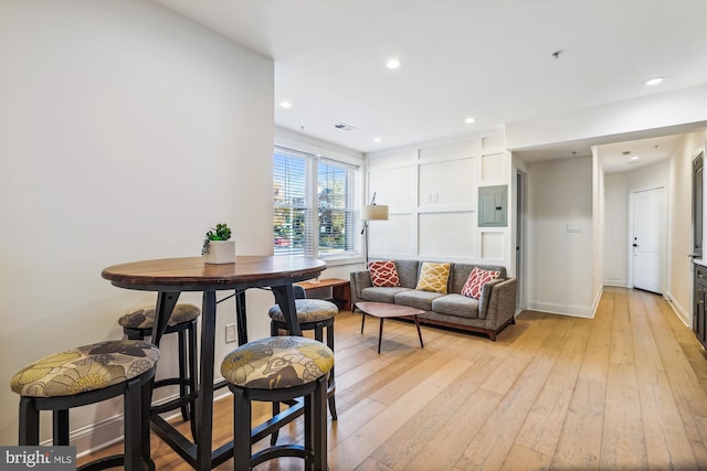 living room with electric panel and light hardwood / wood-style flooring