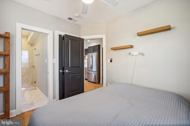 bedroom featuring ceiling fan, stainless steel fridge, light hardwood / wood-style floors, and ensuite bath