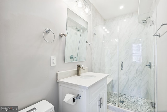 bathroom with vanity, a shower with shower door, and toilet