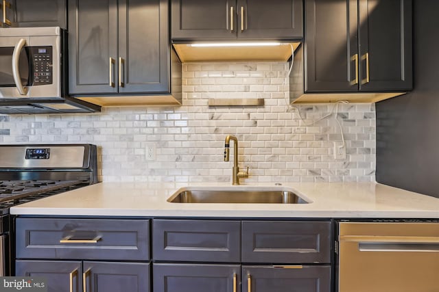 kitchen with tasteful backsplash, light stone countertops, sink, and appliances with stainless steel finishes