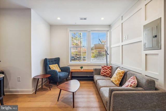 living area with light wood-type flooring and electric panel