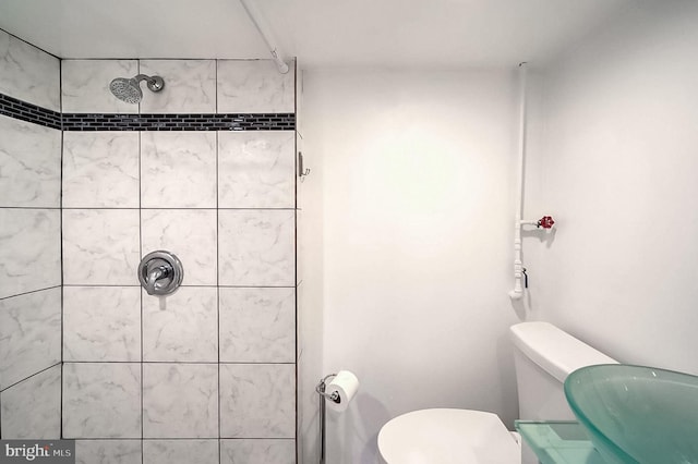 bathroom with tiled shower and toilet