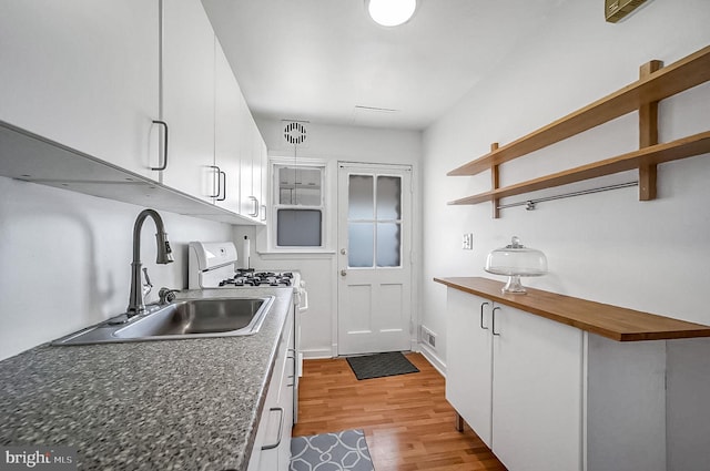 kitchen with sink, white cabinets, white range with gas stovetop, and light hardwood / wood-style flooring