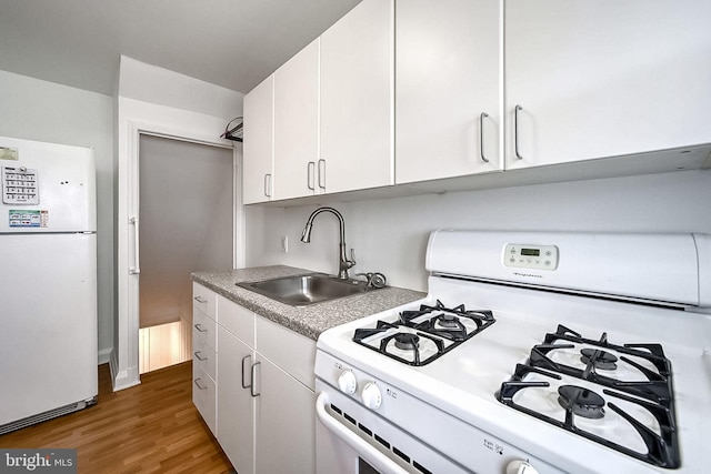 kitchen featuring white cabinetry, dark hardwood / wood-style flooring, white appliances, and sink