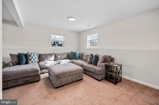 carpeted living room featuring beamed ceiling