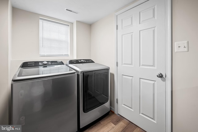 laundry area featuring light hardwood / wood-style floors and independent washer and dryer