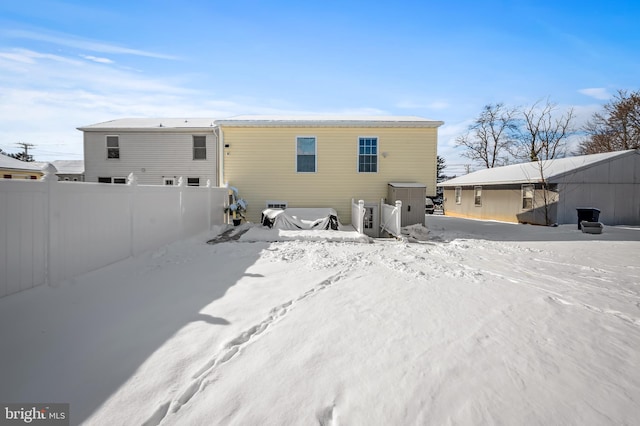 view of snow covered back of property