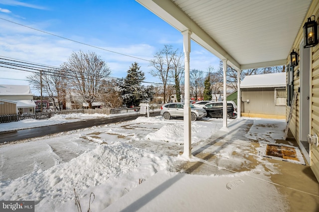 snow covered patio featuring a porch