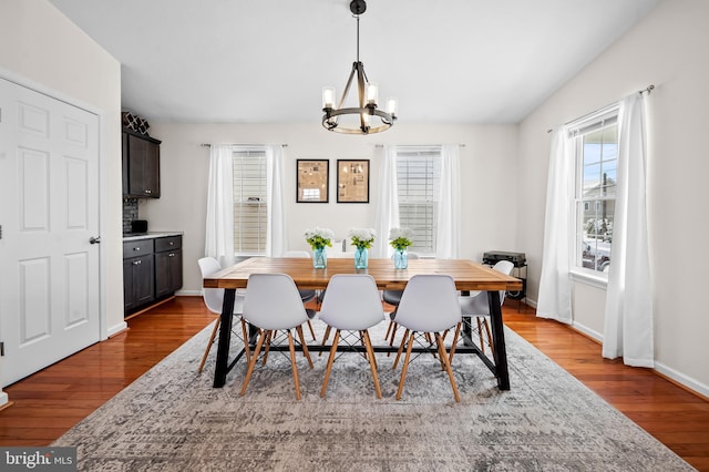 dining space featuring hardwood / wood-style floors and a chandelier