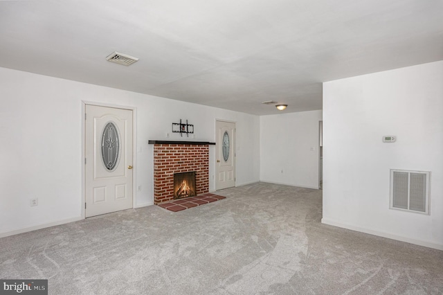 unfurnished living room featuring a brick fireplace and carpet flooring