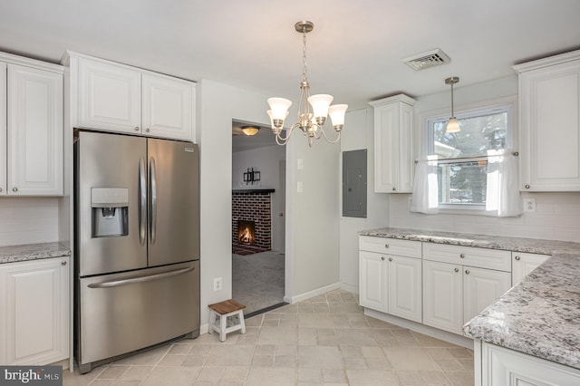 kitchen featuring tasteful backsplash, white cabinets, stainless steel fridge, and pendant lighting