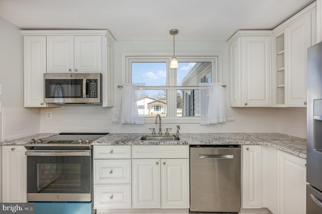 kitchen with backsplash, stainless steel appliances, white cabinets, and sink