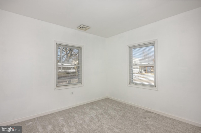 spare room featuring light colored carpet