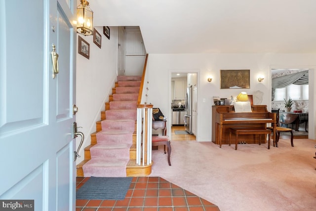 carpeted foyer featuring a chandelier