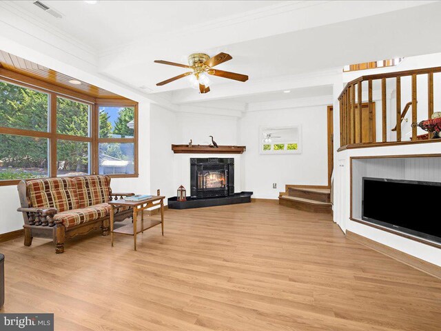 living room featuring ceiling fan, crown molding, and light hardwood / wood-style floors